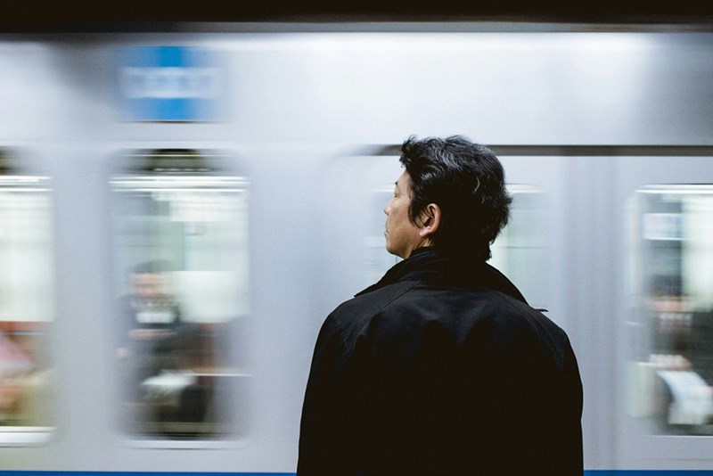 A blurry picture of a man waiting for the subway.