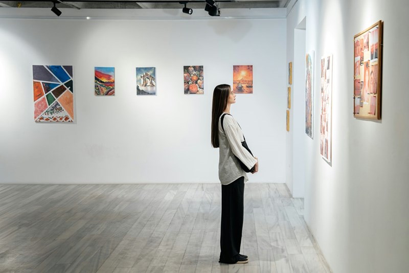 Woman viewing colorful artwork inside a modern museum gallery during a cultural vacation.