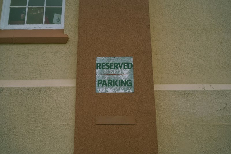 A “reserved parking” sign on the side of a building.