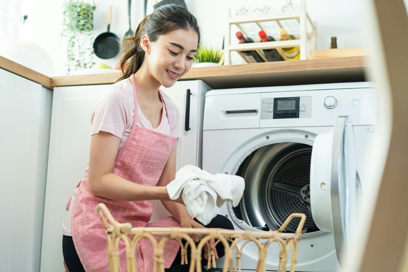 A caretaker is doing her own laundry at her employer's home after she did their laundry, even though she didn't ask for permission. 