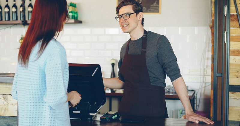 A representation of a male cashier serving a female customer