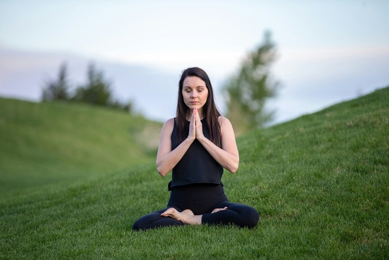 woman meditating on an open field