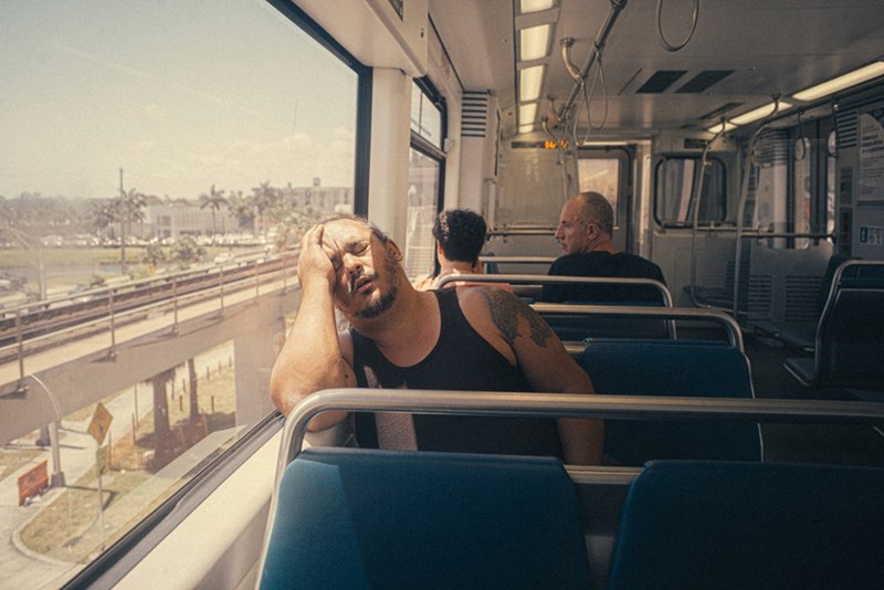 a man pretending he is asleep on a train