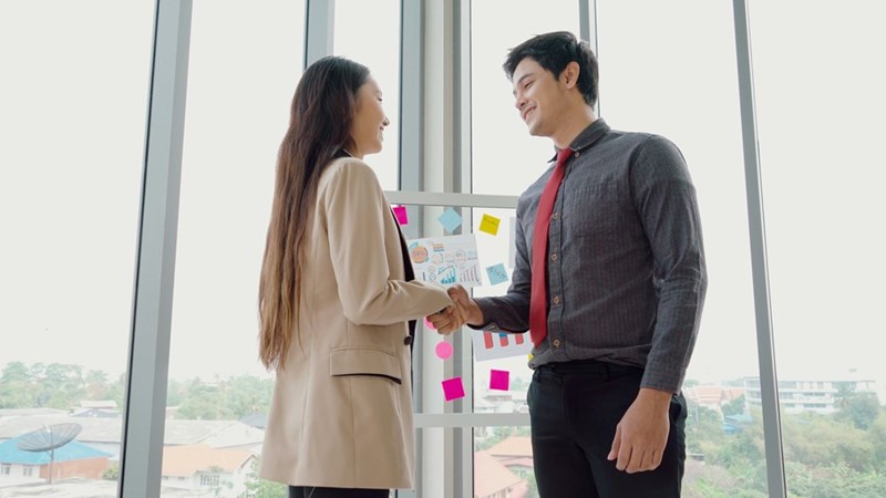 Woman and man shaking hands at an office.