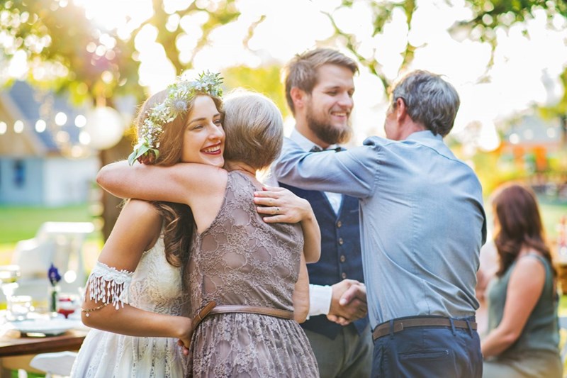 Guest congratulate a bride and a groom at an outside reception
