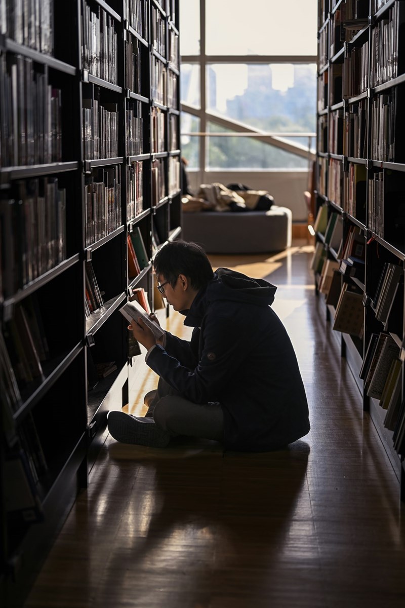 man sitting on the floor in a library