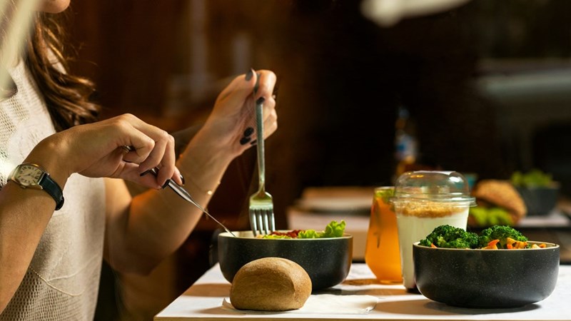 A person eating from a bowl at a restaurant, model image.