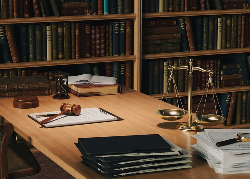 An organized law office with legal documents, case files, and scales of justice, illustrating the professional environment where subtle workplace conflicts can quietly affect daily operations.