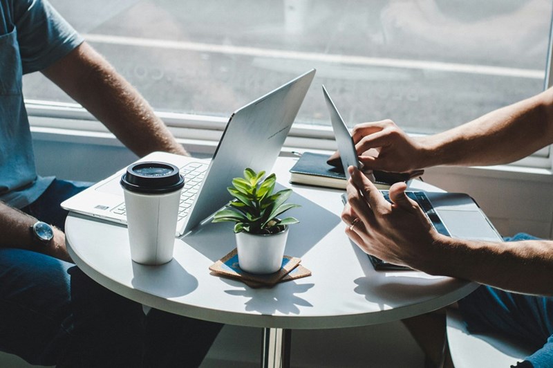 Two people working together on a coffee table, model image.