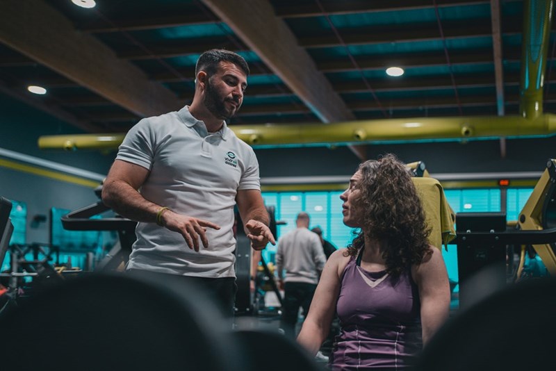 a man talking to a woman at the gym