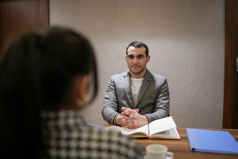 A man waits patiently for the next question in an interview