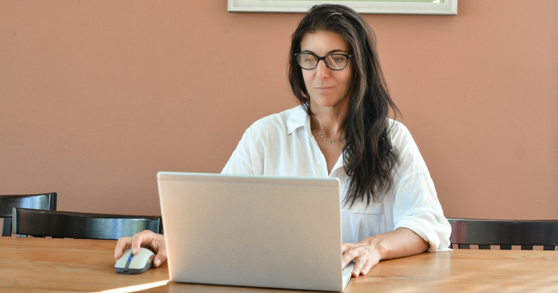 A representation of a manager checking her emails on a laptop