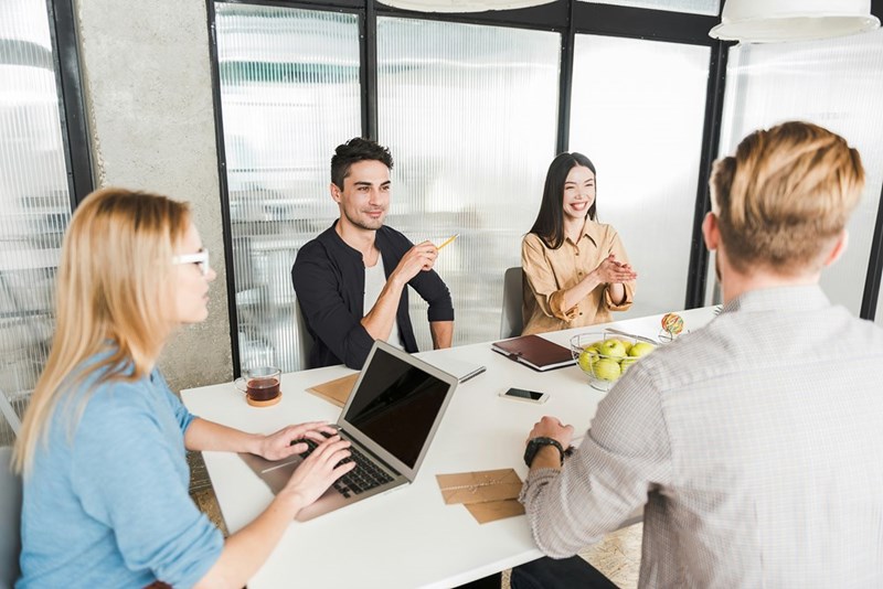 Coworkers gathered for an office meeting, reflecting discussions about workplace expectations and company rules.