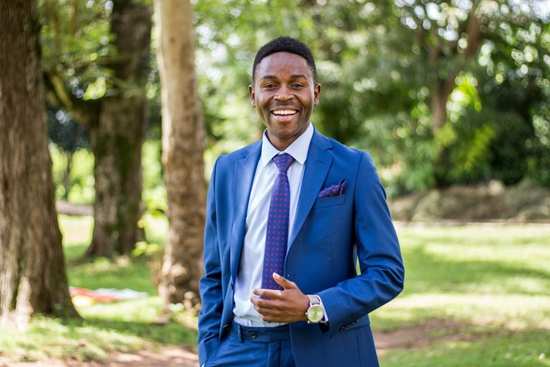 man in blue suit smiles for the camera
