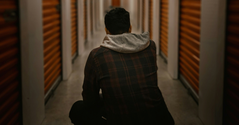A model representing the back of a man crouching down in a hallway of a storage unit