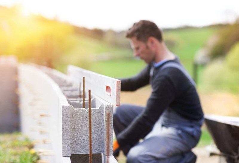 Homeowner installing a property boundary wall.