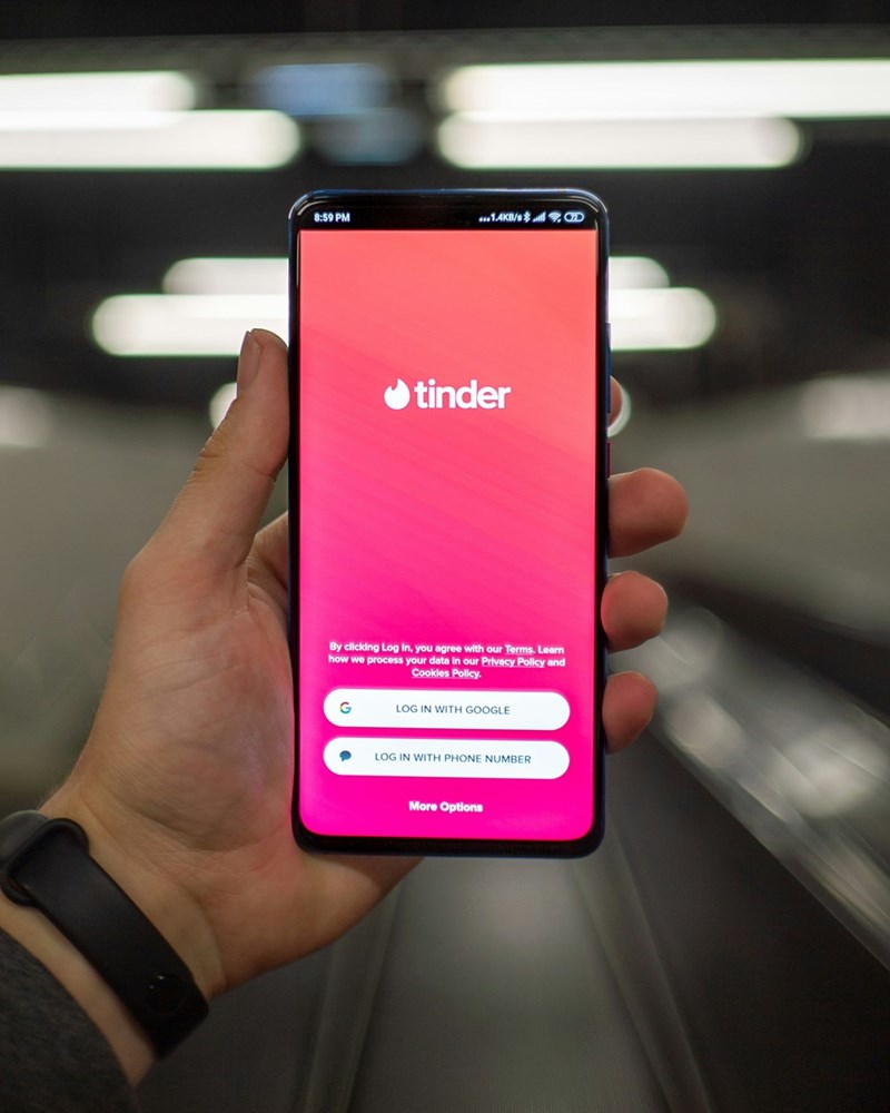 person holding phone with tinder in it