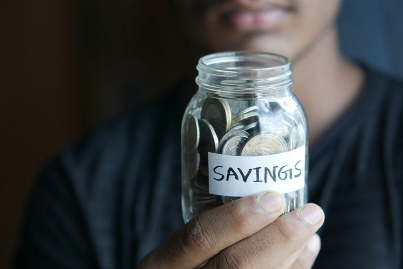 woman holding jar of savings