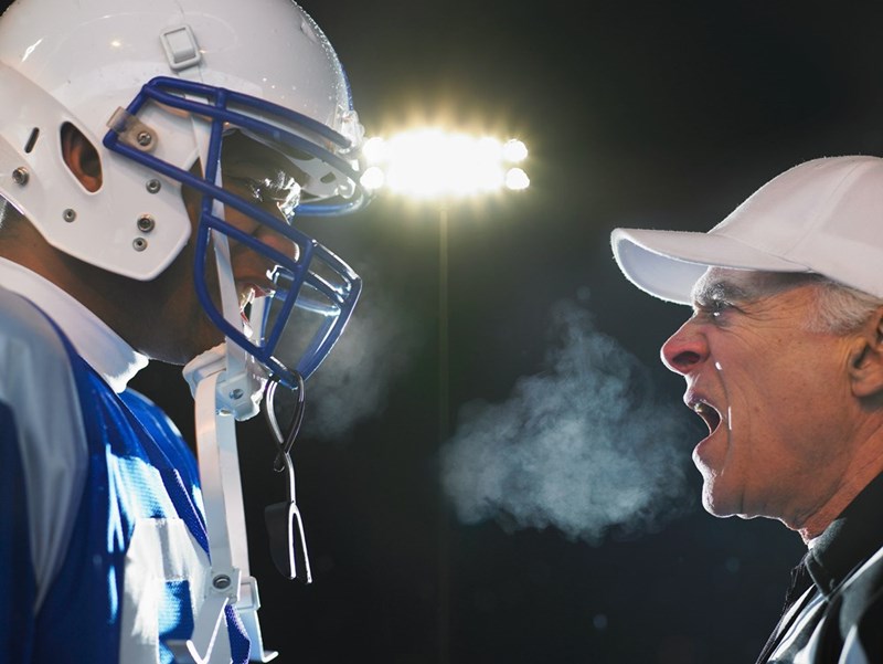 The football coach yells at the student athlete to make him stop talking and start listening to him. 