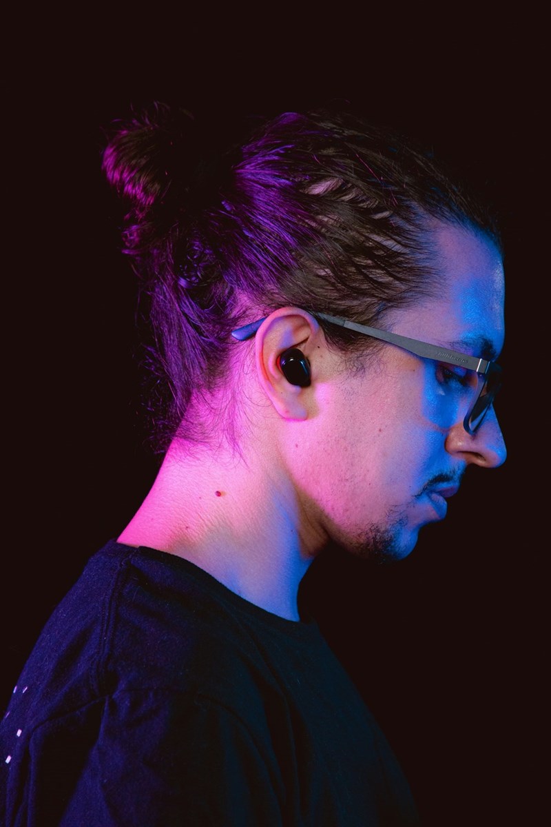Man in black crew neck shirt wearing ear plugs