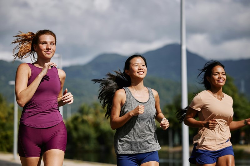 A group of three women running down a street