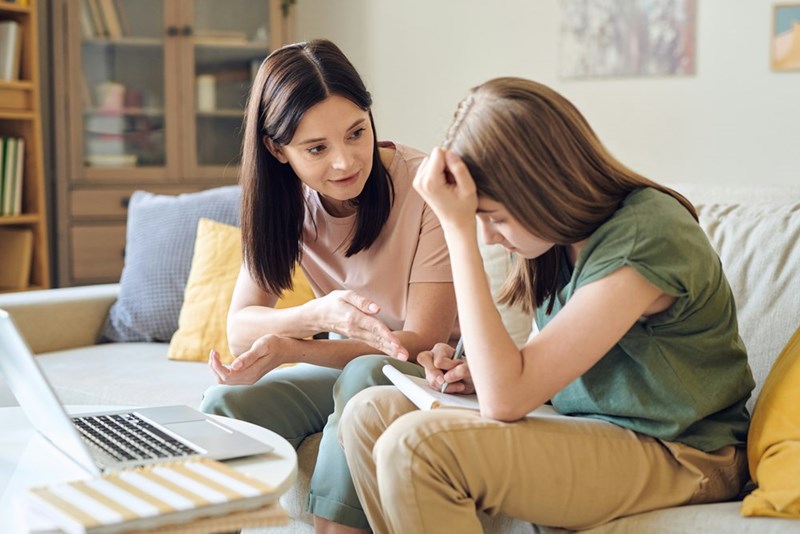 Parent talking with a worried teenager at home.