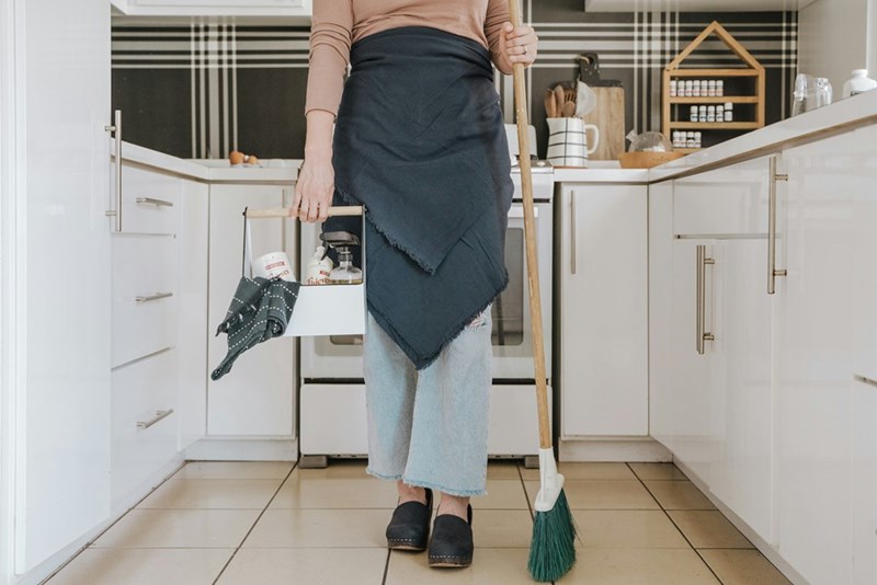 Professional cleaner preparing a rental property's kitchen for house viewings.
