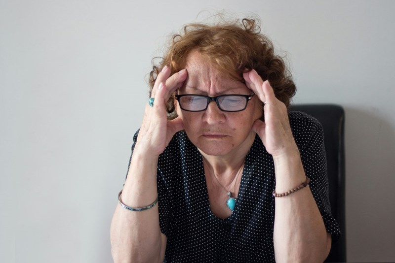 Frustrated landlady reviewing paperwork after a disagreement with tenants over move-out expenses and cleaning costs.