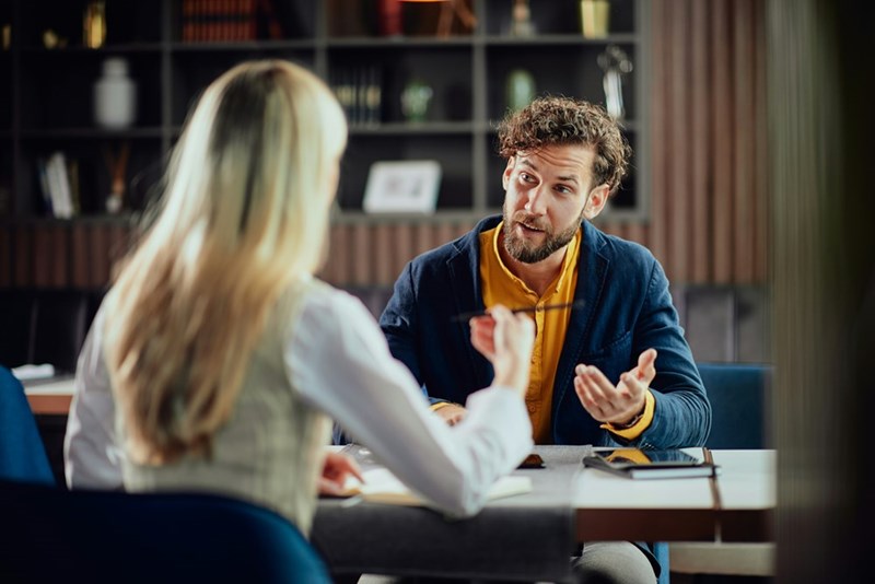 Two coworkers discuss something at their office