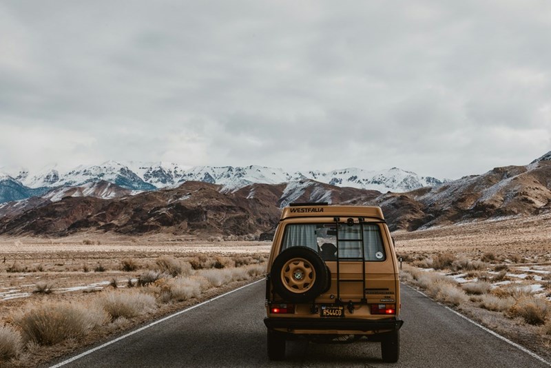 A car is driving to a rural cabin in Montana on a road with very few places to fill up on gas or take a bathroom break.