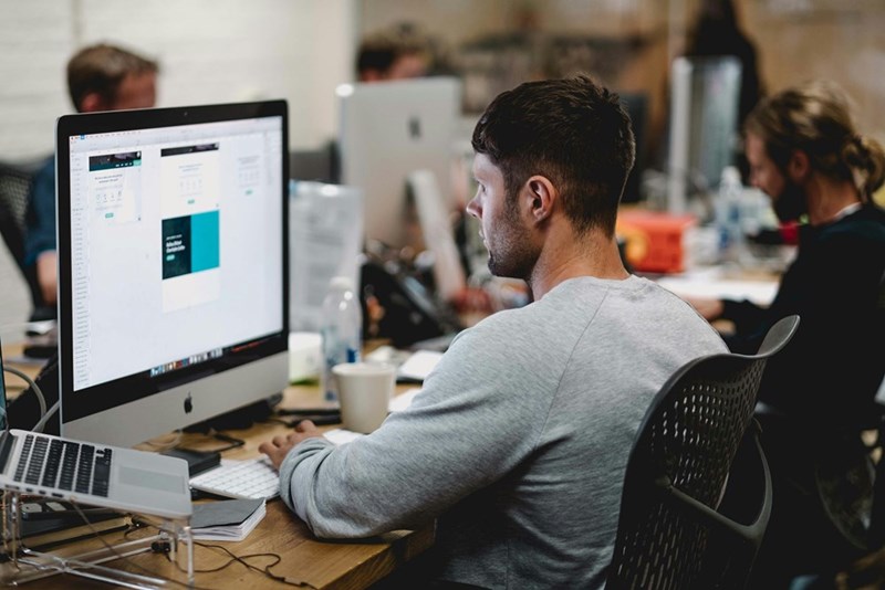 A man looks at a computer at his desk