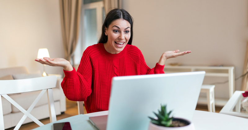 A woman shrugs while taking a video call from home