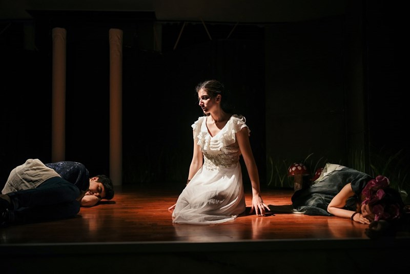 A woman in a white dress sitting on the floor