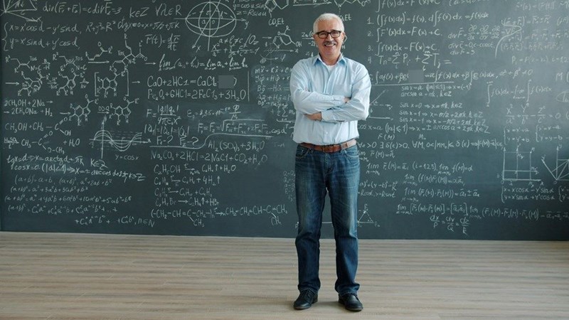 Man in front of chalkboard with math equations