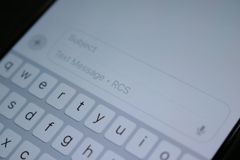 A cellphone showing the messages app and the keyboard.