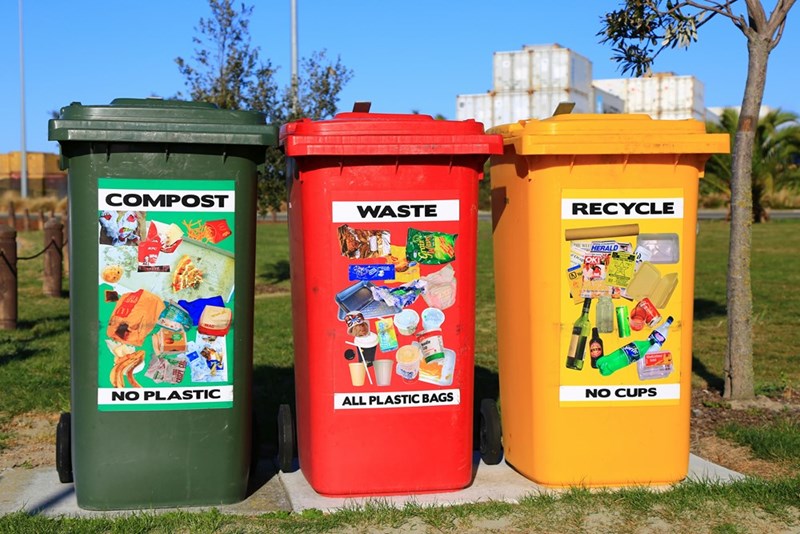 Red, yellow, and green trash bins separated into categories for recycling purposes.