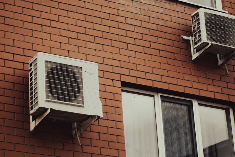 AC units attached to a brick building.