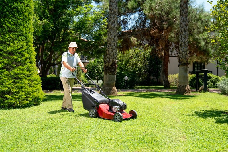 Person mowing a residential lawn.