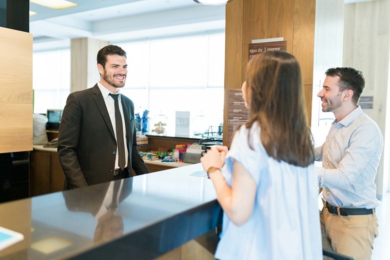 The front desk worker helps the manager and the employee