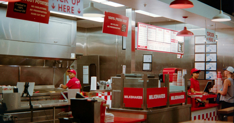 Employees working behind the counter of a fast food restaurant