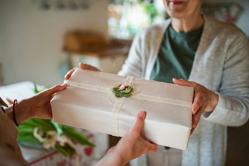 An aunt holding a birthday present she made herself at home for her niece.