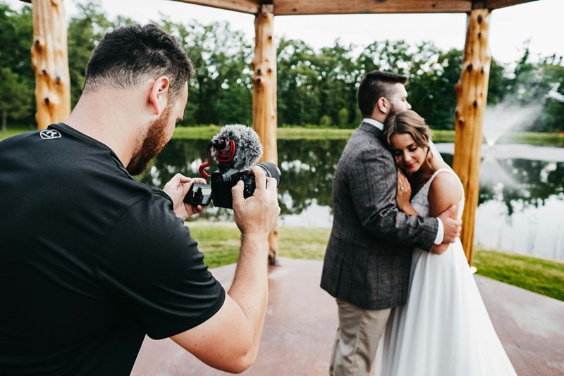 man filming wedding