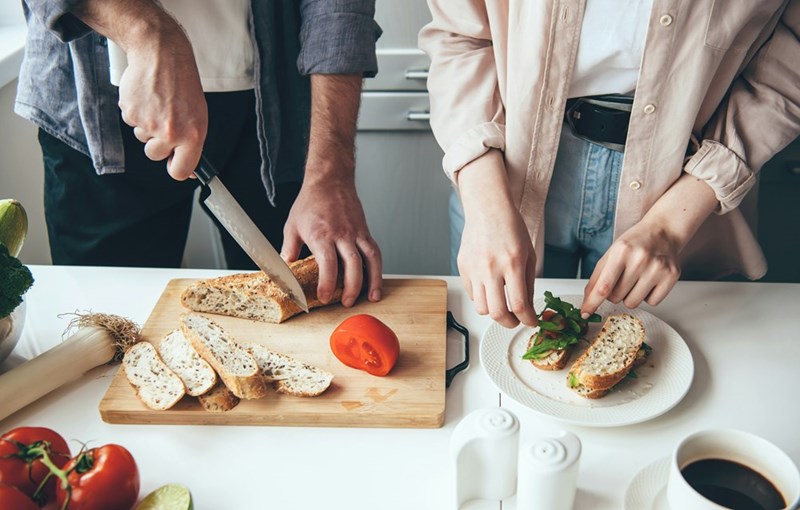 Family members preparing food together in the kitchen.