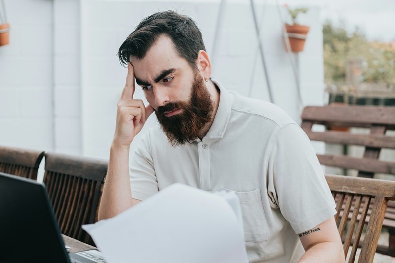 Concerned employee reviewing documents while waiting for a workplace meeting about a disciplinary issue.