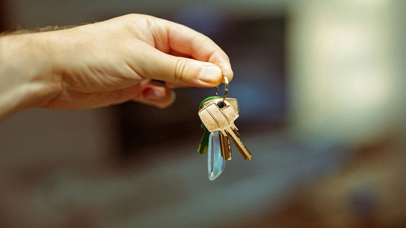 A person holding the keys to a new place to live in their hands.