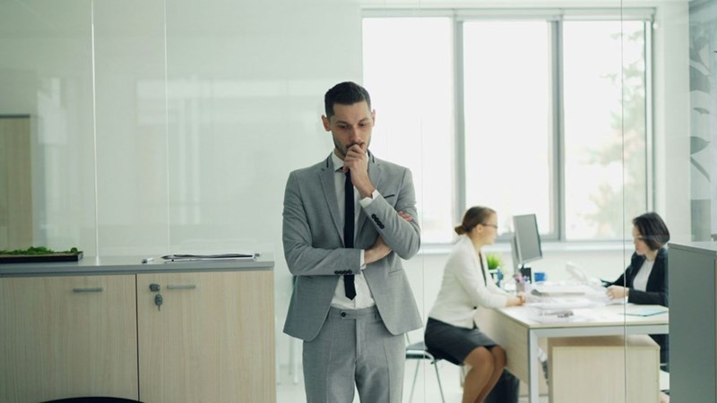 A man looking stressed in an office. Representation.