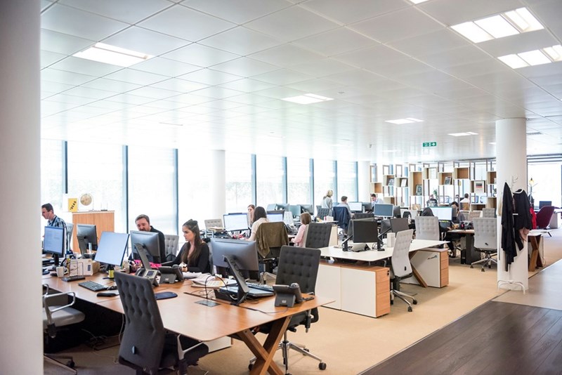 A workplace full of employees and computers.