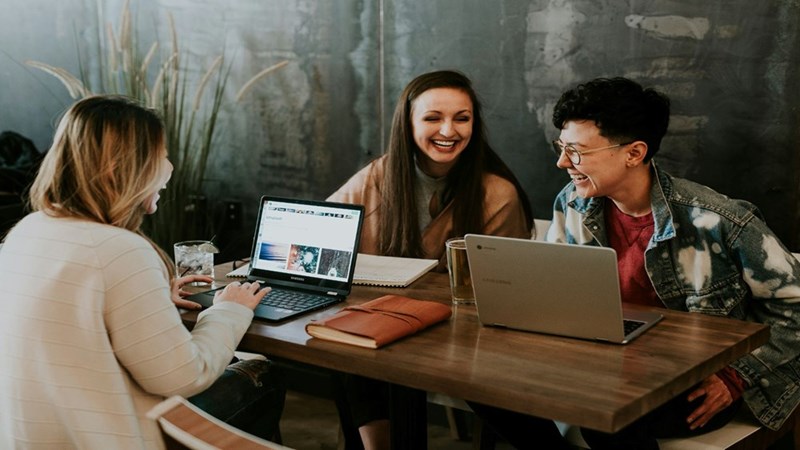 Three coworkers working together on their computers. Representation.