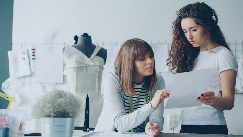 Two workers collaborate on a report.