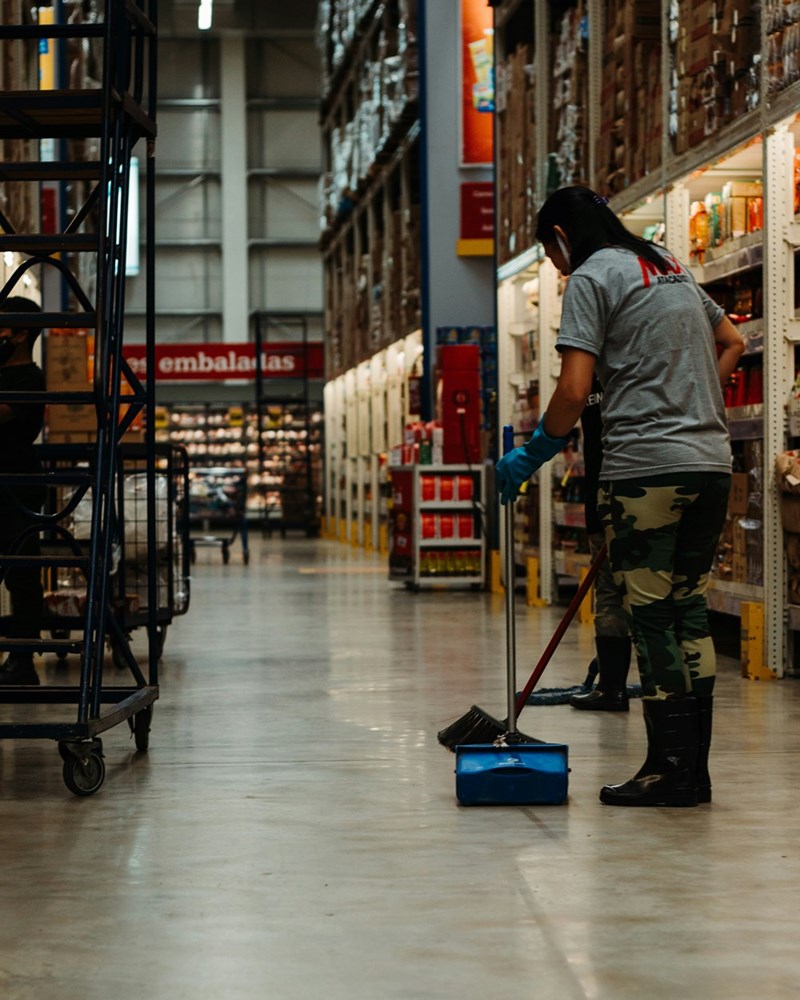 A grocery store employee sweeps the floor after closing.